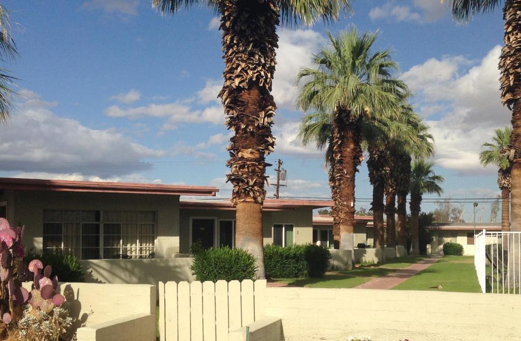 a group of palm trees in front of a building at Stanlunds Inn and Suites in Borrego Springs