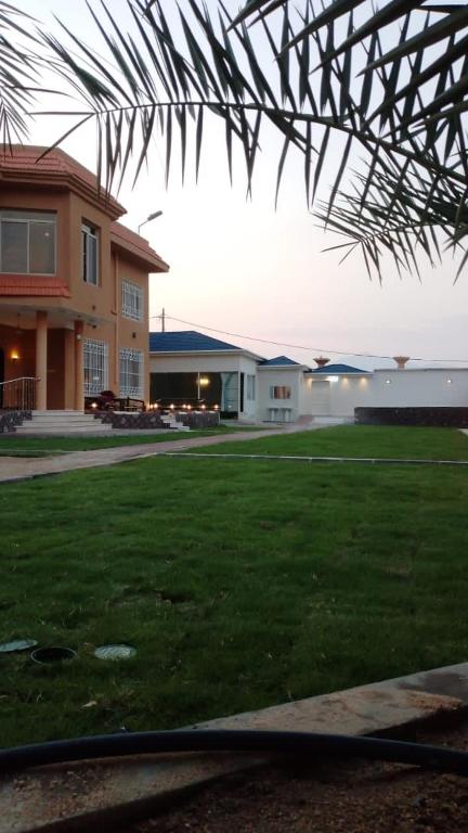a house with a grass yard with a building at شاليه وفيلا اطلالة الكر in Makkah