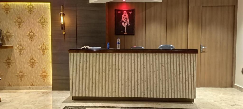 巴德拉普尔Sun Bright Residency Badlapur的大堂的前台,墙上挂着照片