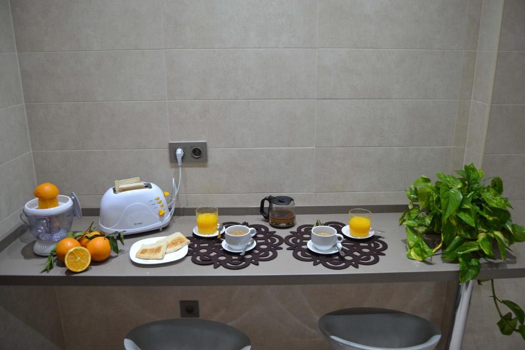 una mesa con dos tazas de zumo de naranja y comida en ella en Apartamento Santa Eulalia, en Mérida