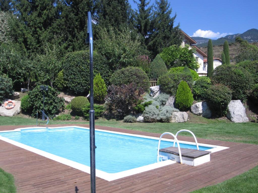 a swimming pool with a bench next to a yard at Hostal Cal Batista in Bagá