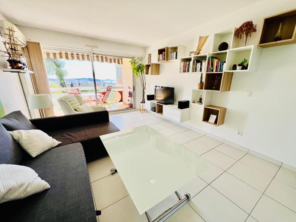 un salon avec un canapé et une télévision dans l'établissement Grand T2 lumineux, avec vue et piscine, à Toulon