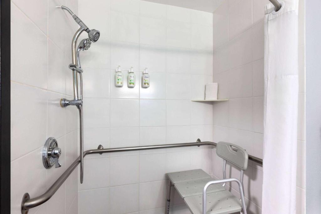 a bathroom with a shower with a bench in it at La Quinta by Wyndham Sevierville / Kodak in Sevierville