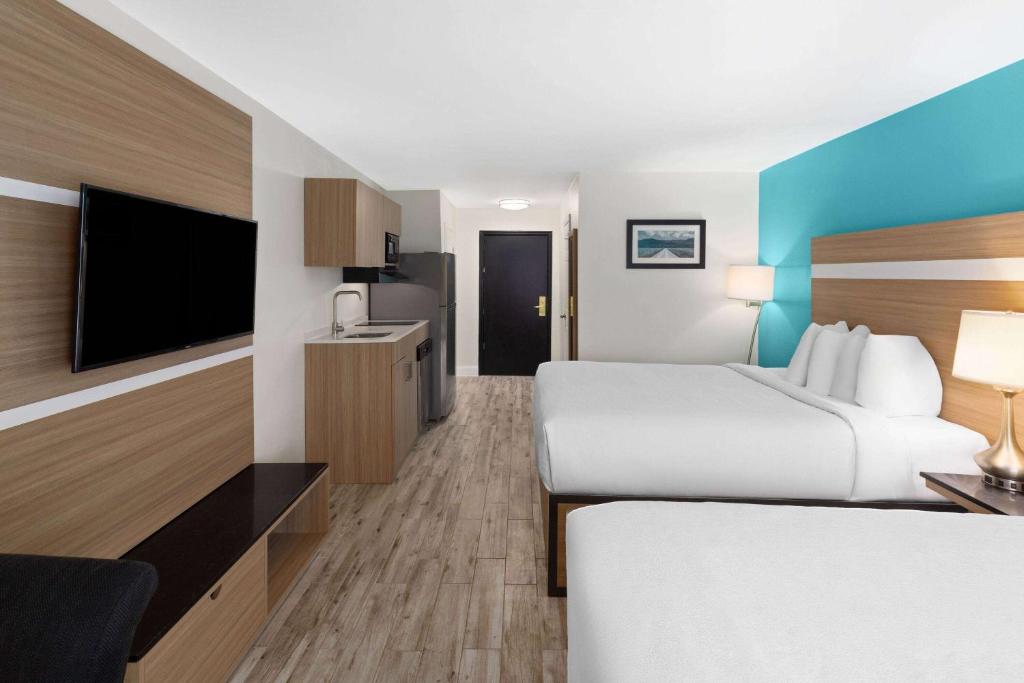 a hotel room with two beds and a flat screen tv at La Quinta by Wyndham Sevierville / Kodak in Sevierville