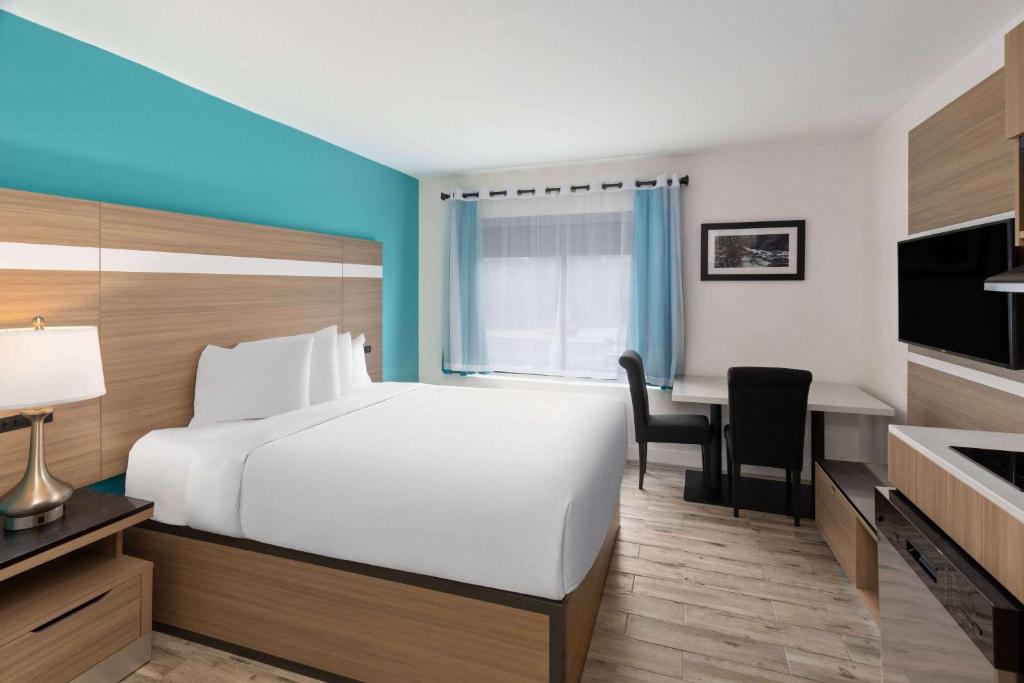 a hotel room with a white bed and a desk at La Quinta by Wyndham Sevierville / Kodak in Sevierville