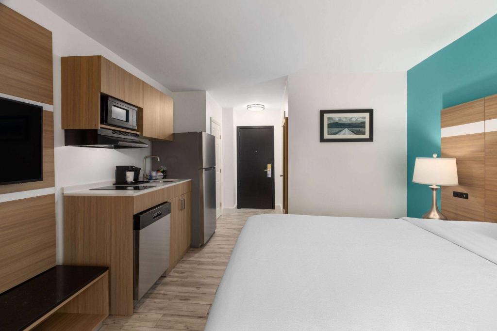 a hotel room with a large bed and a kitchen at La Quinta by Wyndham Sevierville / Kodak in Sevierville