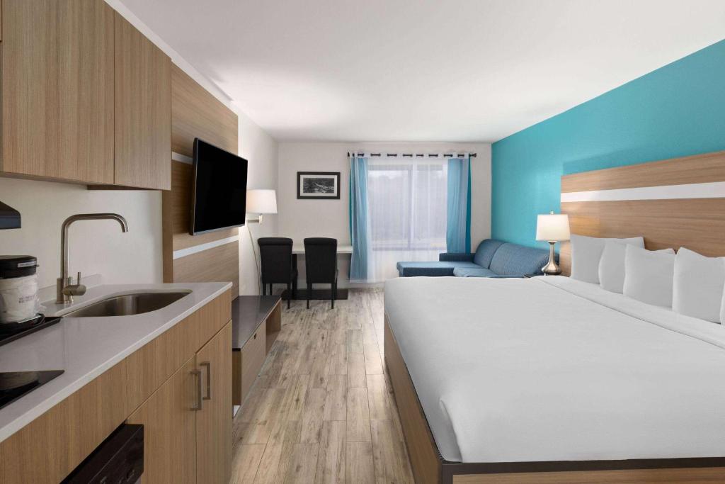 a hotel room with a large bed and a kitchen at La Quinta by Wyndham Sevierville / Kodak in Sevierville
