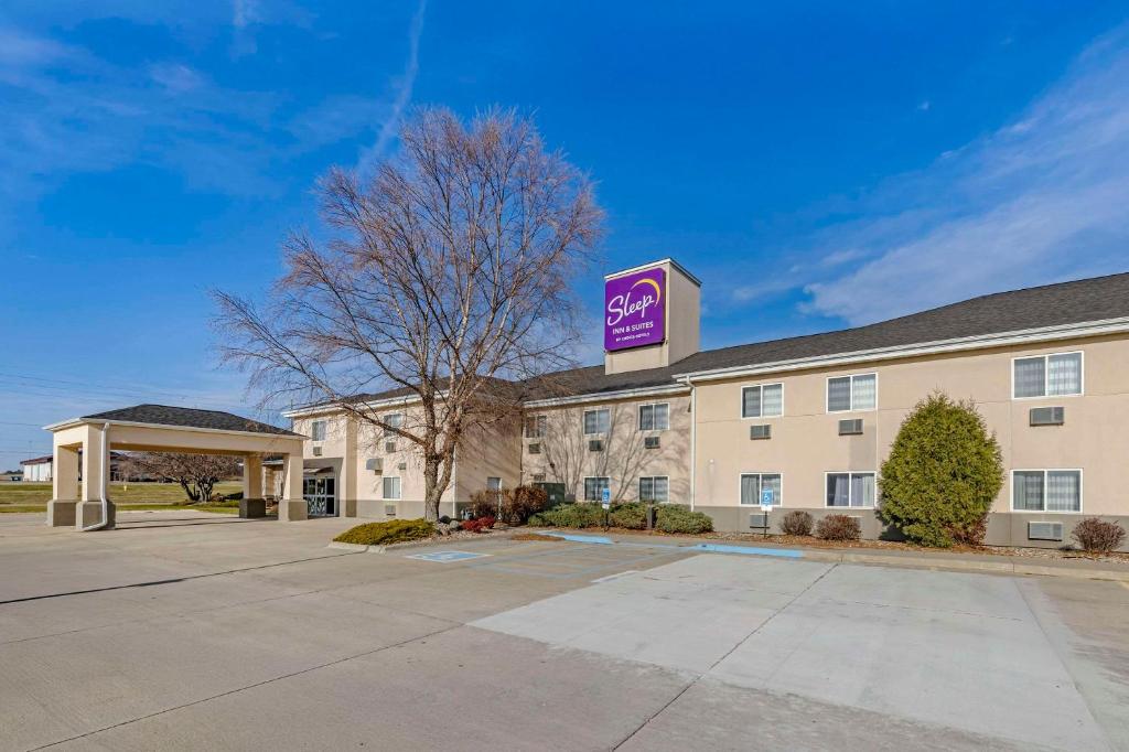 a hotel with a purple sign on top of it at Sleep Inn & Suites Charles City in Charles City