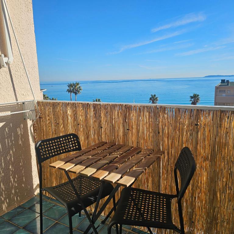 une table et des chaises sur un balcon avec l'océan dans l'établissement Studio 2 personnes Vue Mer Climatisé Linge Maison, au Lavandou