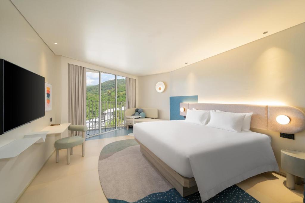 una habitación de hotel con una cama y un televisor en Centara Karon Resort Phuket, en Karon Beach