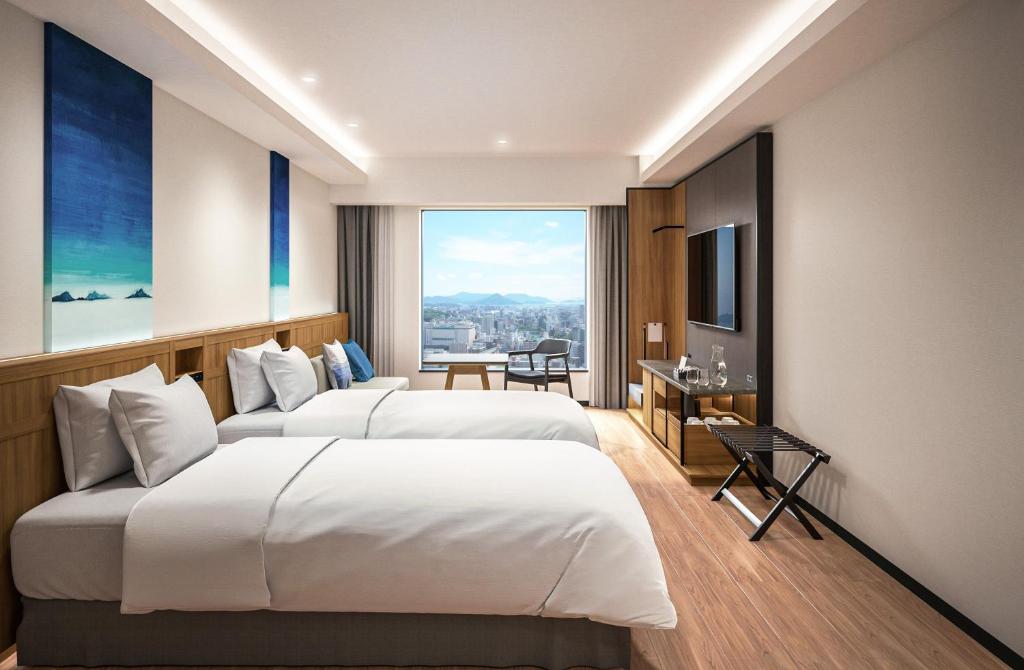 Postel nebo postele na pokoji v ubytování HOTEL GRANVIA HIROSHIMA SOUTH GATE