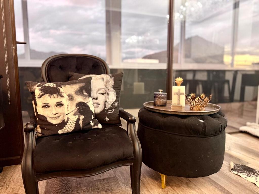 a black chair with a pillow and a table at Dior Maison de Reve- Private Penthouse in Stellenbosch