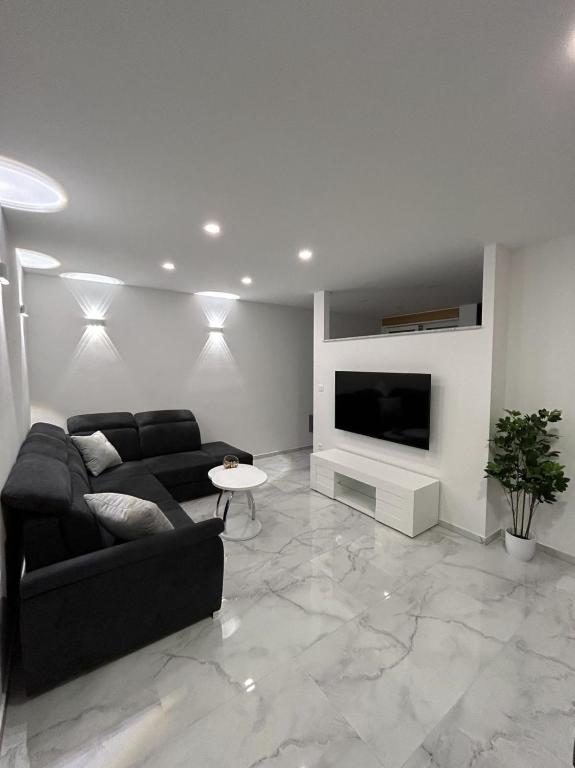 a living room with a couch and a flat screen tv at MA-LU apartment Osijek in Osijek