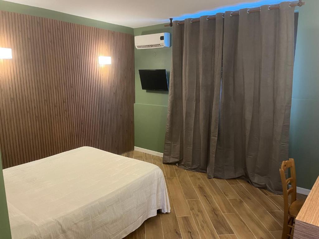 una camera ospedaliera con un letto e una finestra di Hotel Ginepro a Qualiano