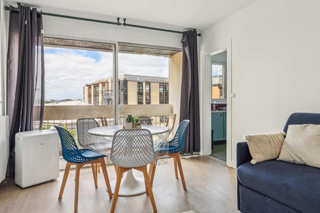 un salon avec une table, des chaises et un canapé dans l'établissement Le Familial - Charming apartment in Paris, à Paris