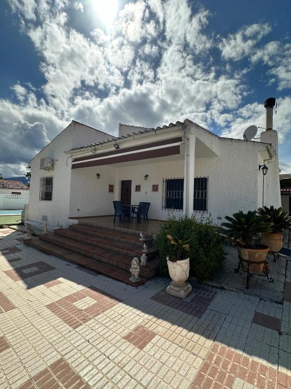 a white house with a porch and a patio at Chalet independiente en zona residencial rural con piscina privada in Jaén