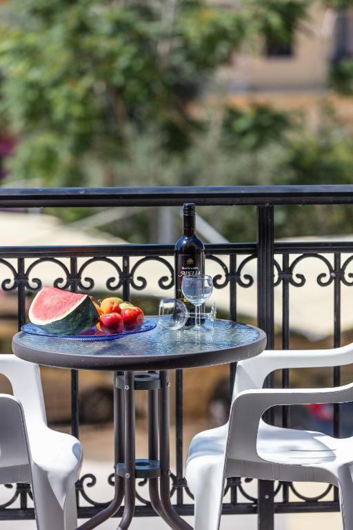 a table with a bottle of wine and a plate of fruit at Old town studio with balcony, Marylee's studios #3 in Rethymno