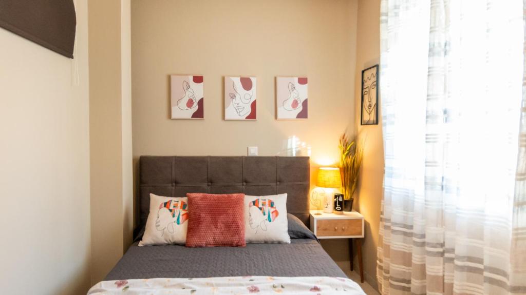 a bedroom with a bed with two pillows at The Greens premium house - Luxury Apartment in the Heart of the City by Villa Mana Gers in Zakynthos Town
