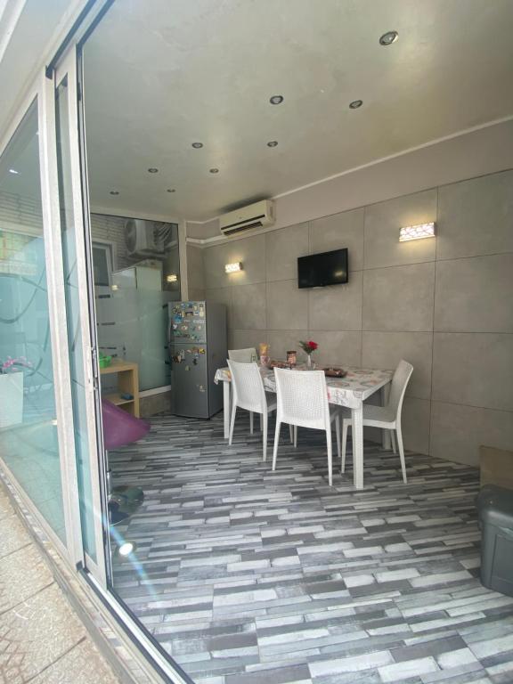 a dining room with a table and white chairs at Luxury Rosaverde in Frattamaggiore