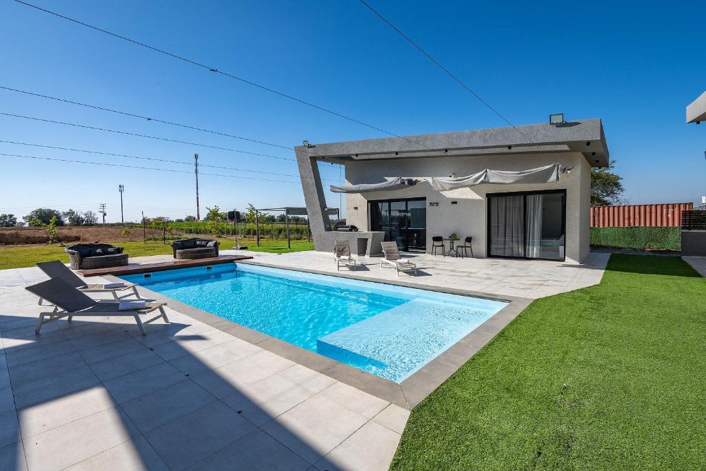 a swimming pool in the yard of a house at נופש Eylim -וילה מהממת עם 3 סוויטות ובריכה פרטית מחוממת in Sede Ẕevi