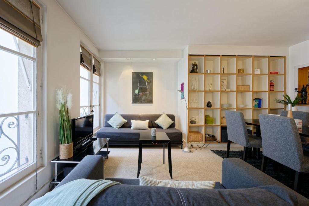 un salon avec un canapé et une table dans l'établissement Appartement Cosy au Coeur du marais, Paris !, à Paris