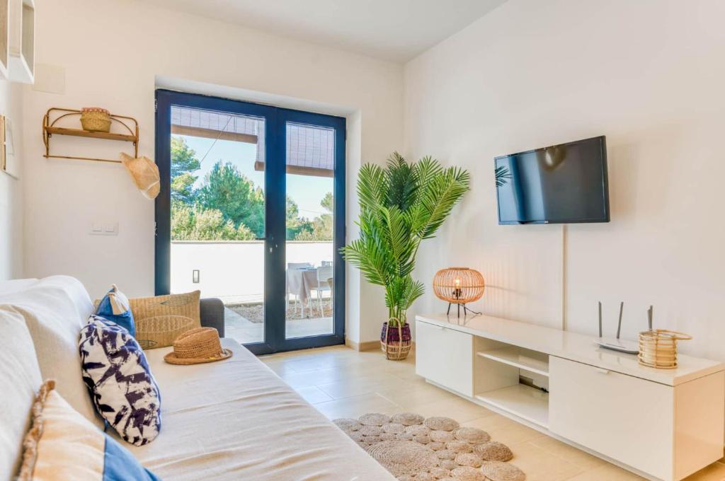 Una sala de estar con un sofá y un televisor. en Son Carrió 6, en Son Carrio
