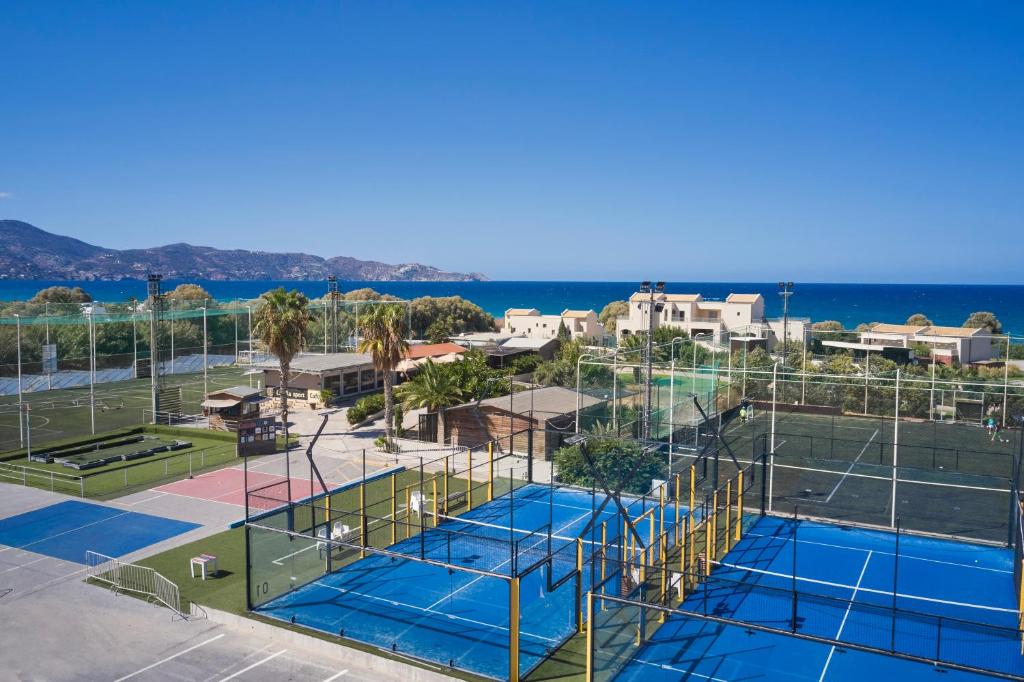 an aerial view of two tennis courts with the ocean at TUI Magic Life Candia Maris - Adults Only in Amoudara Herakliou