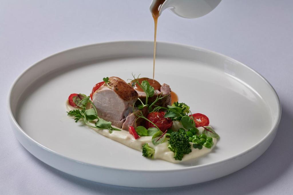 a white plate with a piece of food on it at TUI Magic Life Candia Maris - Adults Only in Amoudara Herakliou