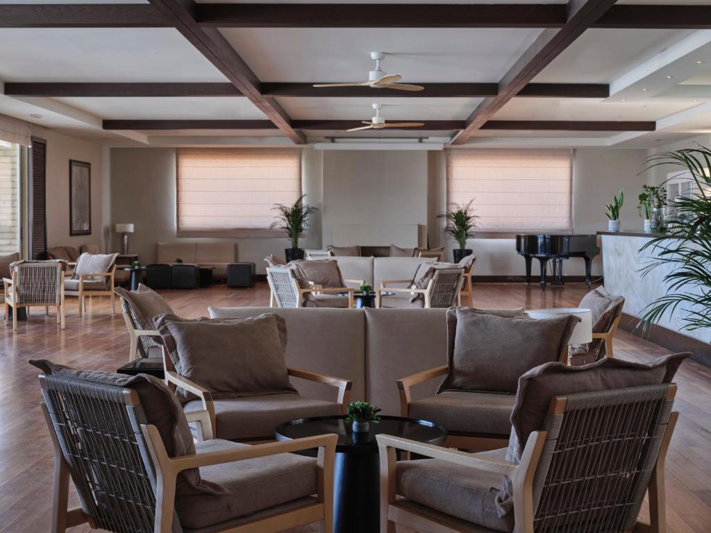 a large room with chairs and tables and a piano at TUI Magic Life Candia Maris - Adults Only in Amoudara Herakliou