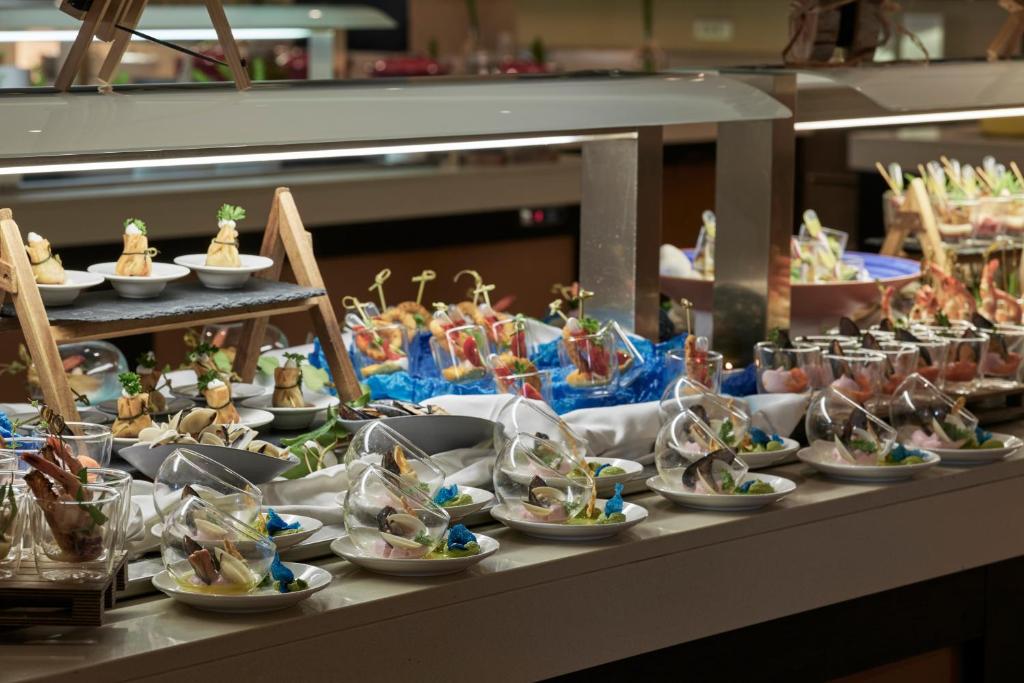 a buffet filled with plates of food on a table at TUI Magic Life Candia Maris - Adults Only in Amoudara Herakliou