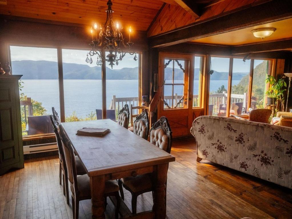 une salle à manger avec une table et une vue sur l'océan dans l'établissement Chalet de la Montagne, à Sainte-Rose-du-Nord