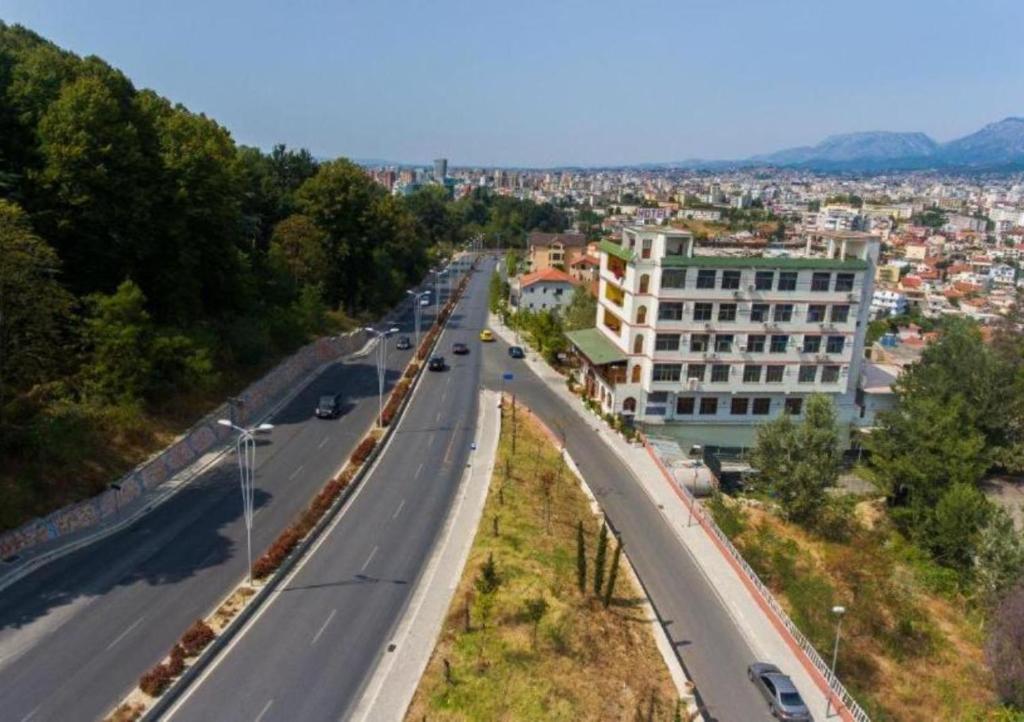 a highway with a building and a city in the background at Hotel Arberia in Tirana