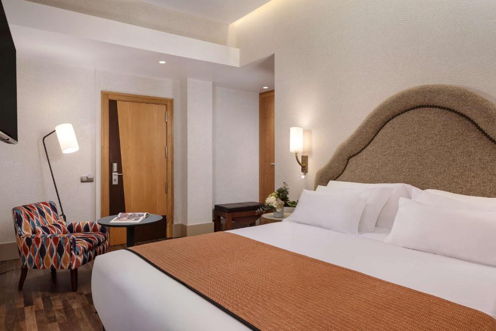 A bed or beds in a room at NH Collection Madrid Paseo del Prado