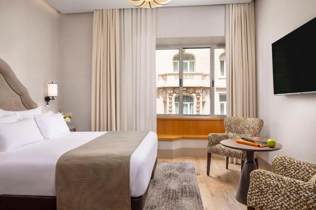 A bed or beds in a room at NH Collection Madrid Paseo del Prado