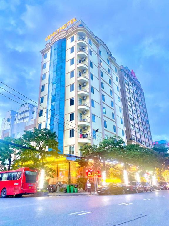 a large building with a red bus in front of it at Kenny Hotel Ha Long in Ha Long