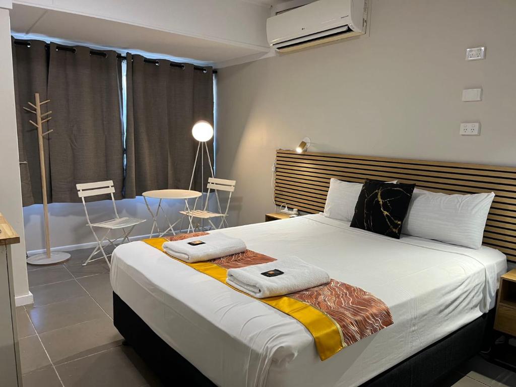a bedroom with a large bed with two towels on it at Kalua Motel in Bundaberg