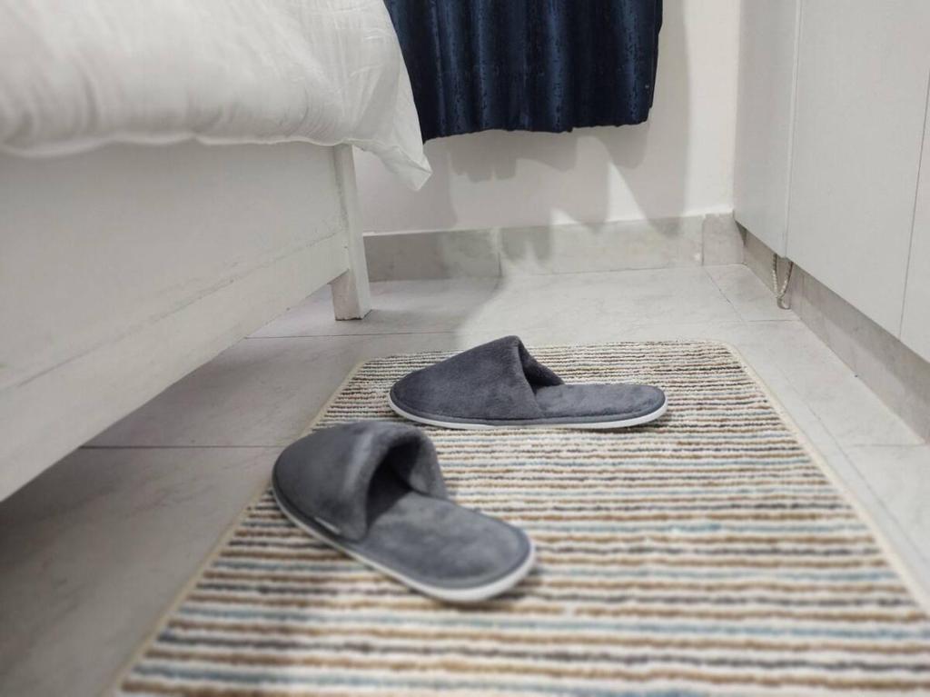 a pair of shoes on a rug on a bedroom floor at One bedroom apartment Aviv in Nairobi