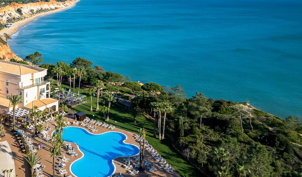 an aerial view of a resort with a pool and the ocean at PortoBay Blue Ocean in Albufeira