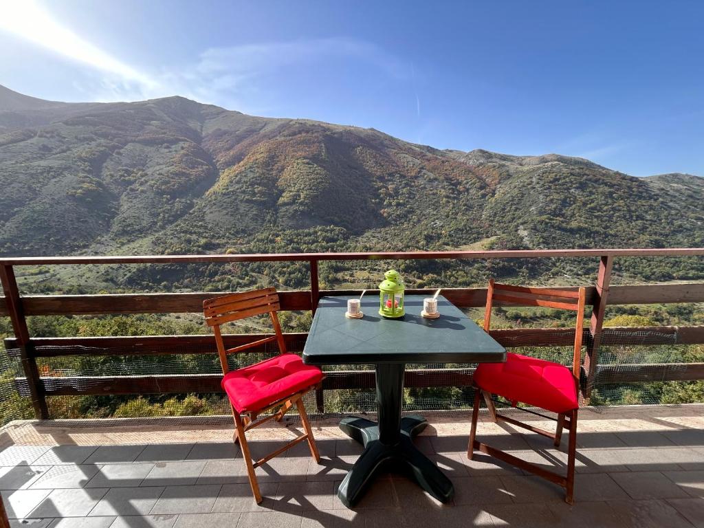 a table and chairs on a balcony with a view of mountains at La Casetta in Montagna by Holiday World in Lucoli Alto