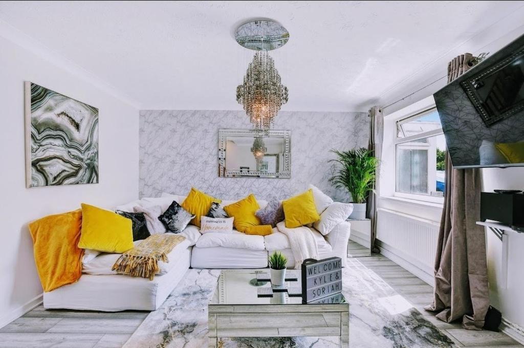 a living room with a white couch and yellow pillows at Luxury Lodge Gillingham with Hot Tub and Parking in Hoo