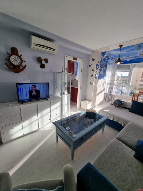 a living room with a couch and a tv at Apartamento Algarrobo Costa Clarin Sea in Algarrobo