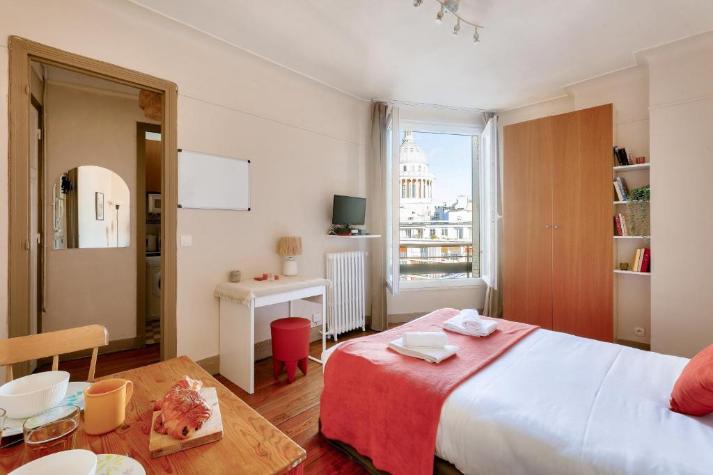 une chambre avec un lit, une table et un bureau dans l'établissement Quiet & Bright Studio-Prime Loc-Pantheon Paris 05, à Paris
