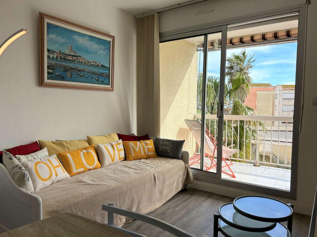 un salon avec un canapé et une grande fenêtre dans l'établissement Appartement 2 pièces - Gruissan GN450-A205, à Gruissan