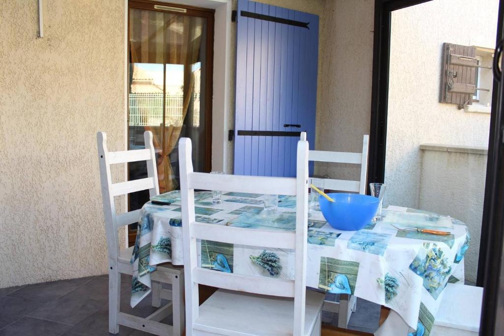 - une table avec deux chaises et un bol bleu dans l'établissement Maison 3 pièces mezzanine - Gruissan GN520-048, à Gruissan