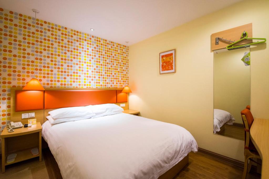 ein Hotelzimmer mit einem Bett und einem Spiegel in der Unterkunft Home Inn Shijiazhuang West 2nd Ring Road Huai'an Road in Shijiazhuang
