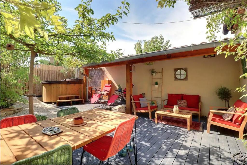 un patio avec une table et des chaises en bois dans l'établissement l'Oasis de Grand'Ma, à Aix-en-Provence
