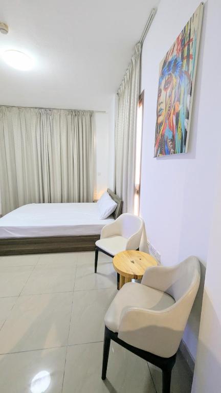 a room with a bed and two chairs and a table at Dragon Premium Homes in Dubai