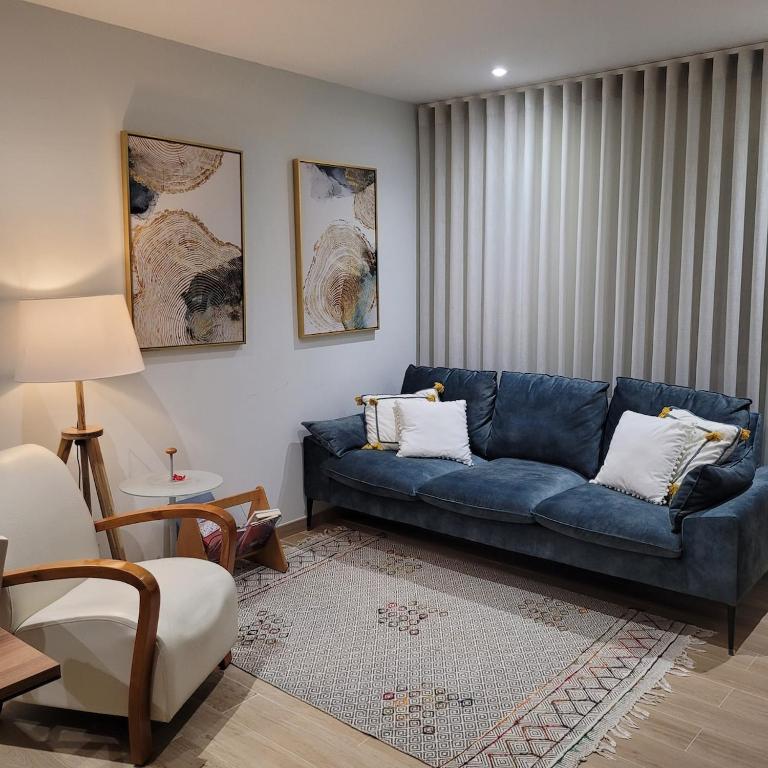 a living room with a blue couch in a room at Dunas Ria Apartment T2 in Gafanha da Encarnação