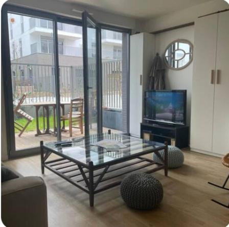un salon avec une table en verre et une télévision dans l'établissement Le Familial - À deux pas de Paris - 03B, à Rueil-Malmaison