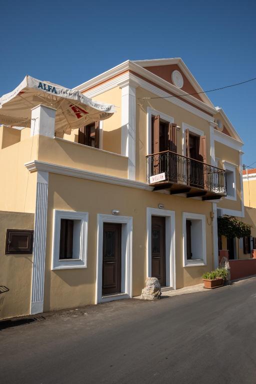 a large house with a balcony on a street at Villa Elizabeth in Symi
